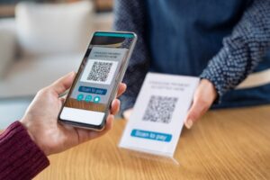 Customer hand scanning qr code with phone for digital payment