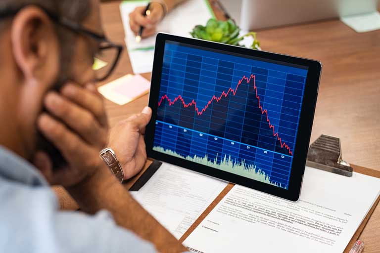 Men lookig at the stock market crashing on an ipad screen