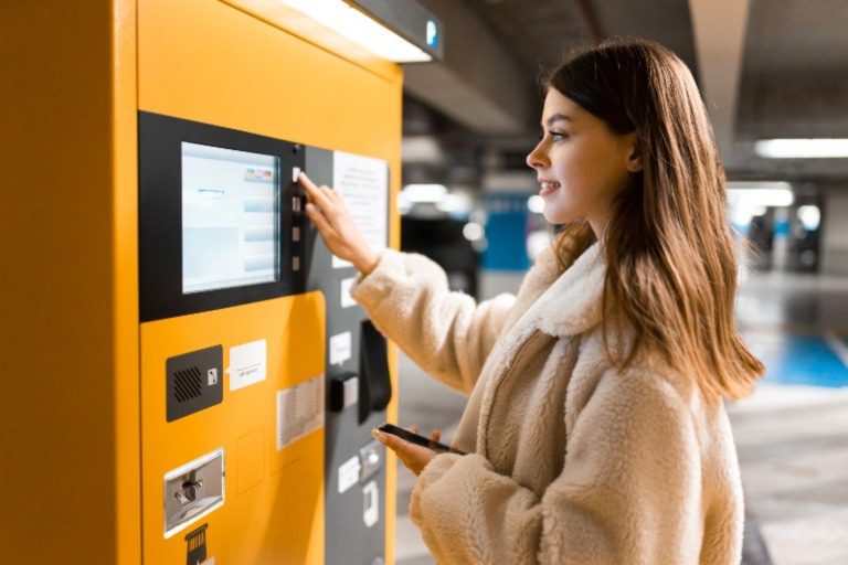 Woman paying for parking at a payment station