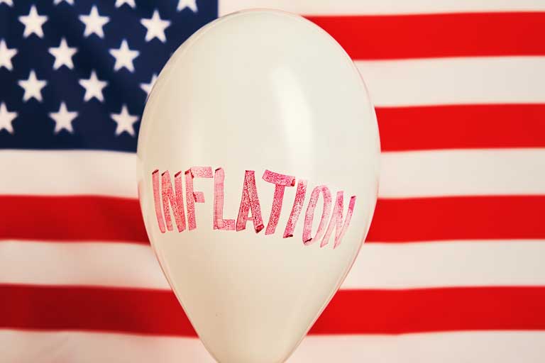 Inflation word written on a balloon in front of an american flag