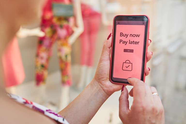 Woman making an purchase through a smartphone pay now buy later