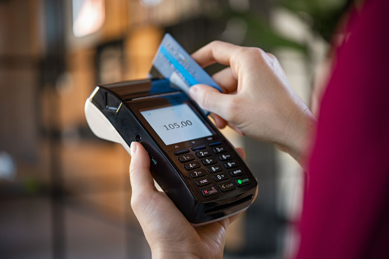 Person swiping a credit card through a payment terminal