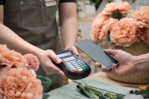 Customer paying with a smartphone at a flower shop