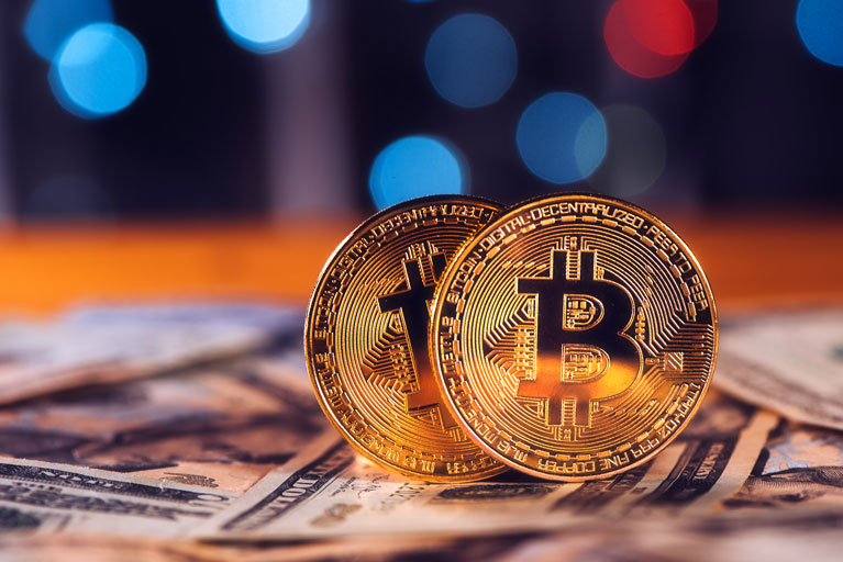 Bitcoin coins on top of us dollars