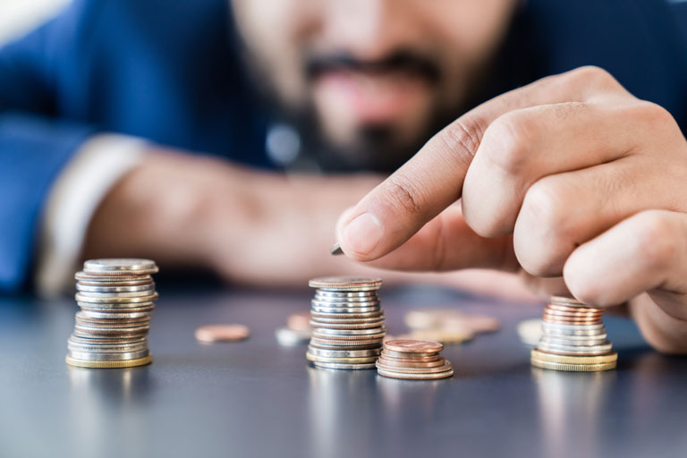 Businessman stacking coins on top of each other