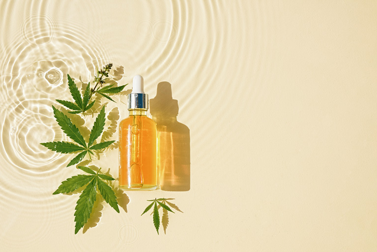 A Bottle of CBD oil and marijuana plans floating on water