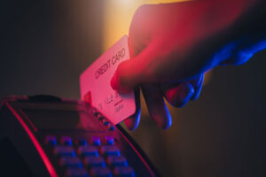 Hand swiping a credit card on a payment terminal