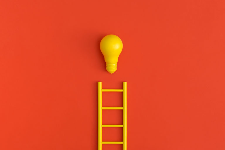 Concept of a lightbulb at the end of a ladder