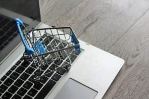 Mini shopping cart on top of a laptop