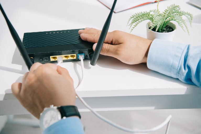 men connecting an ethernet cable to a modem