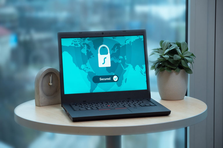 Laptop on top of a table with the screen on showing a secure network