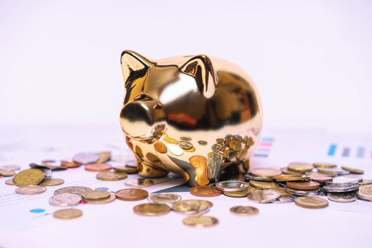 Gold piggy bank with coins around