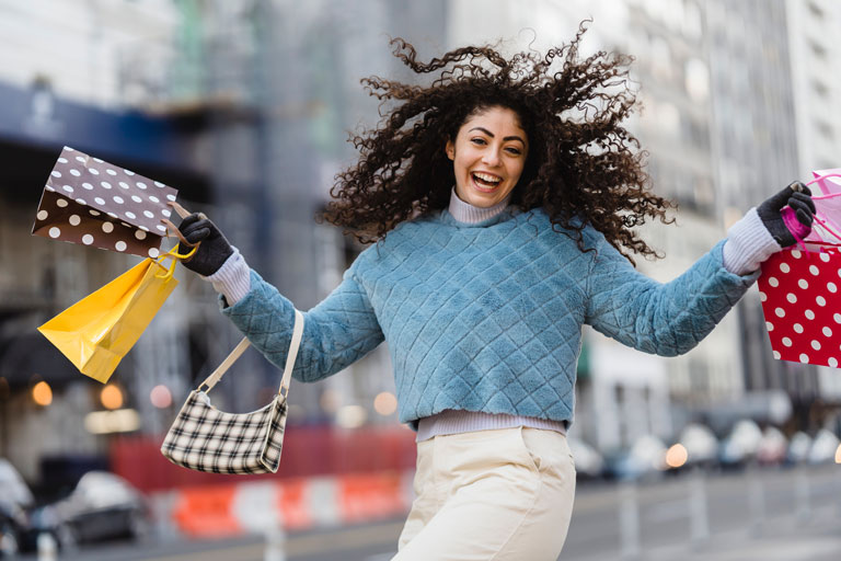 Happy Woman Holding shopping bags and dancing