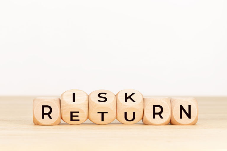 Wooden block with the words risk and return written