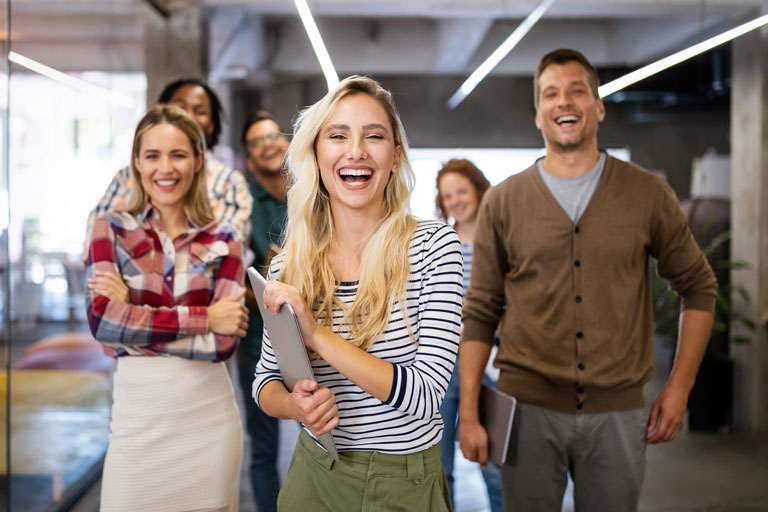 Business professionals inside an office smiling at the camera