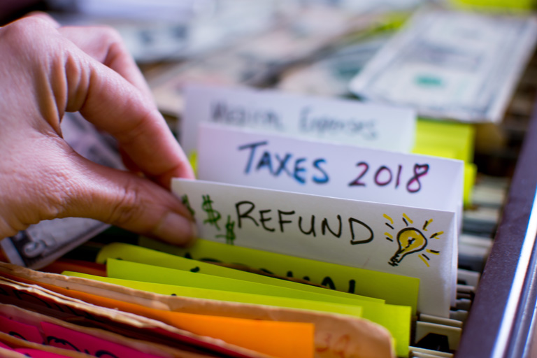 Woman looking through folders labeled as taxes and redfunds