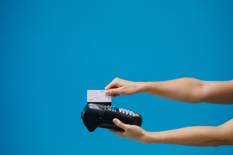 Woman using a credit card payment terminal to pay with her credit card