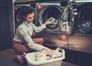 Woman doing laundry inside a laundromat