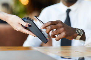 African american man paying at a restaurant with his phone through nfc payment