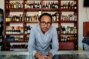 Liquor store business owner laying on a counter