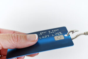 Woman holding a credit card with a fishhook conceptualizing theft