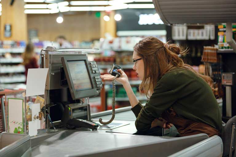 A cashier looking confused at her computer screen