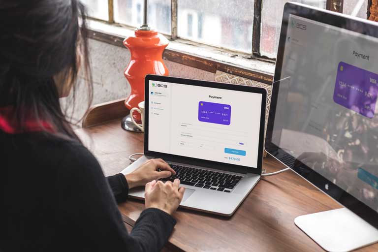 Woman shopping on a laptop connected to a bigger screen