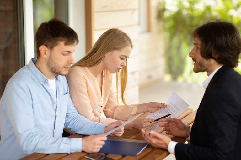 Three people discussing with papers