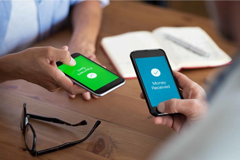 Two people sending money with their phones. One screen says 'Payment Sent' and is green, while the other says 'Money Received' and is blue.