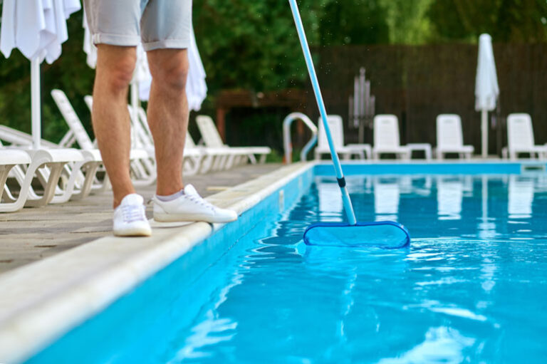 Pool maintenance employee cleaning a pool