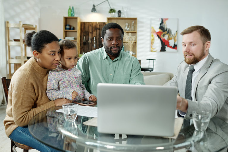 Loan officer explaining to an african american family the terms and conditions of a loan in their living room