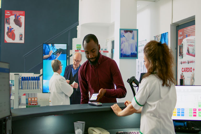 African american man paying for medicine with his smartphone at a medicine store