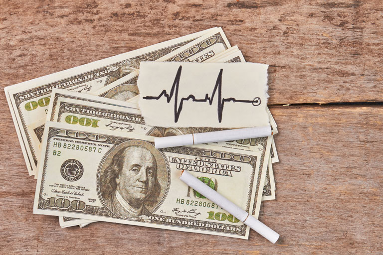 100 dollar bills and 2 cigarettes on top