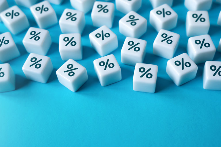 Numerous dice with the percentage symbol engraved, over a blue surface