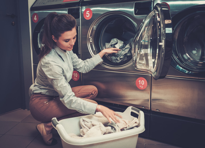 Woman doing her laundry inside a laundry room