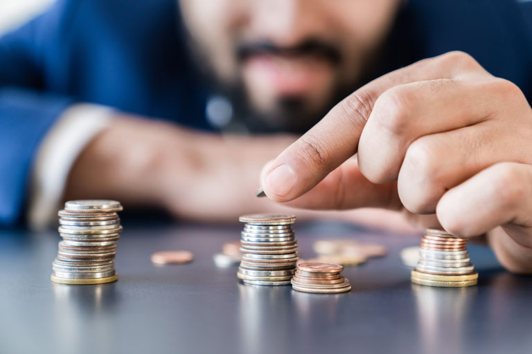 Businessman stacking small coins on top of each other