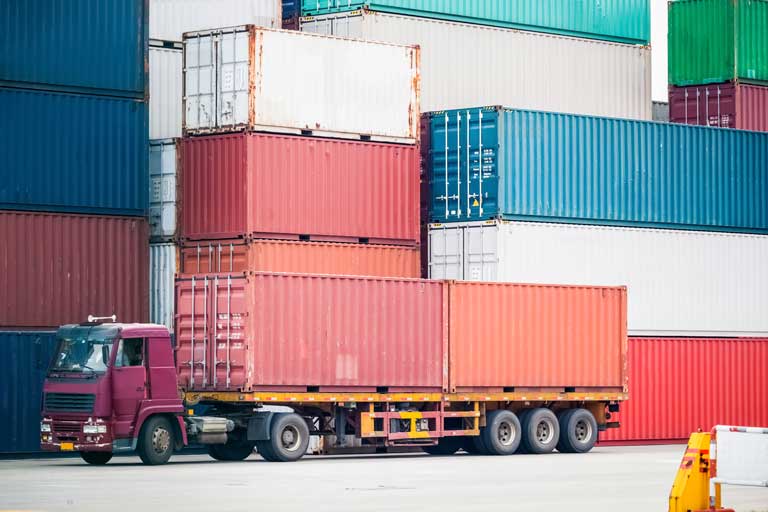 Cargo truck inside a port hauling 2 red containers