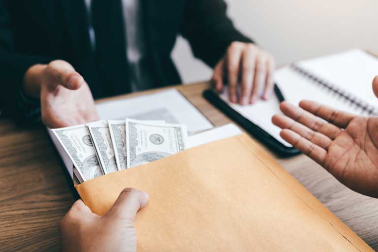 Loan officer handing out an envelope full of cash to a customer