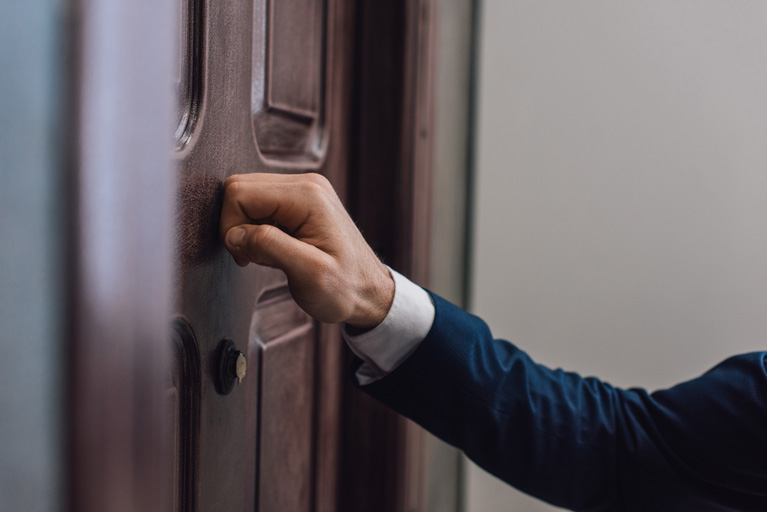 Door to door salesman knocking on a door