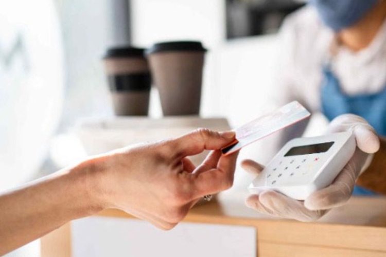 Someone tapping their card to pay at a wireless terminal.