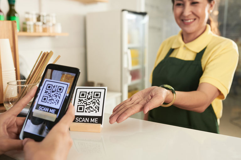 Customer scanning a QR code menu with a phone at a juice store