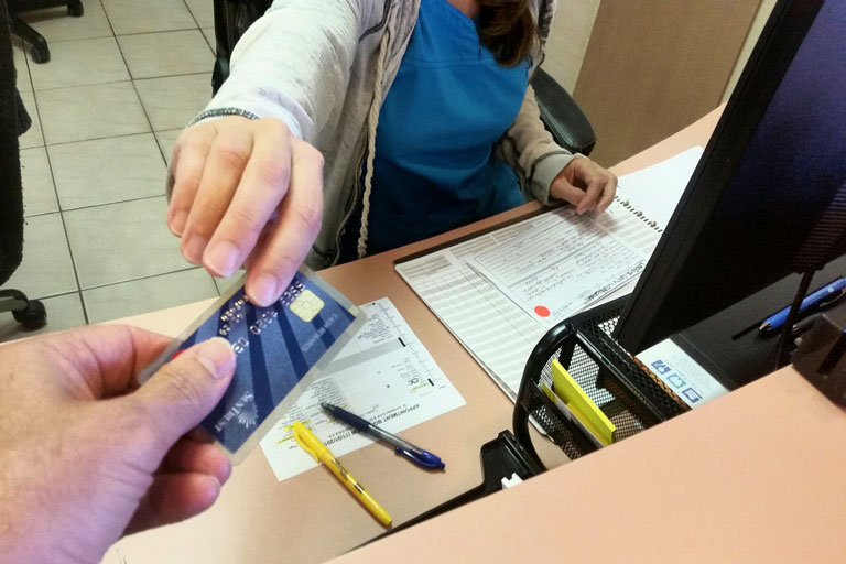 Man paying with a credit card at a dental office