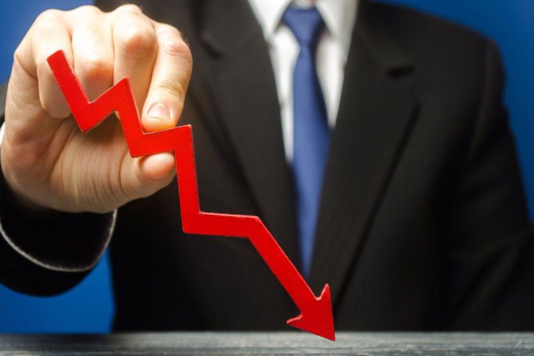 Businessman holding a downwards trend red arrow