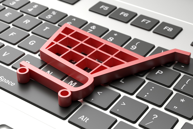 Red shopping cart on top of a computer keyboard