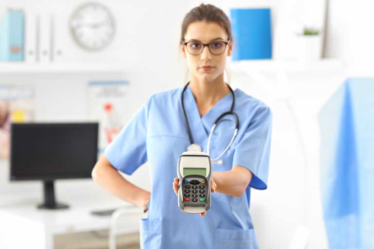 Female doctor holding a payment terminal in front of a customer