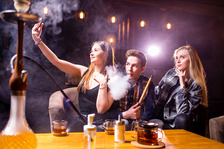 3 friends having drinks and smoking at a hookah lounge