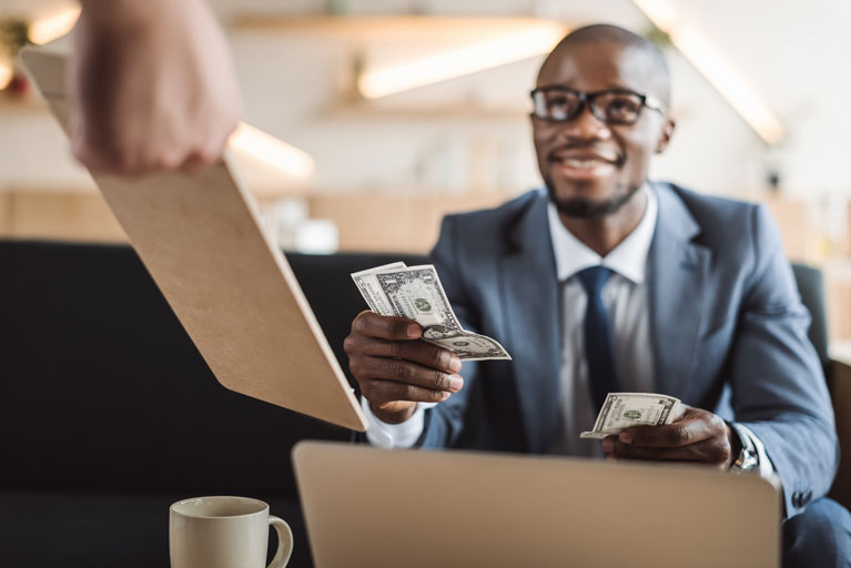 African American man paying at a restaurant with cash