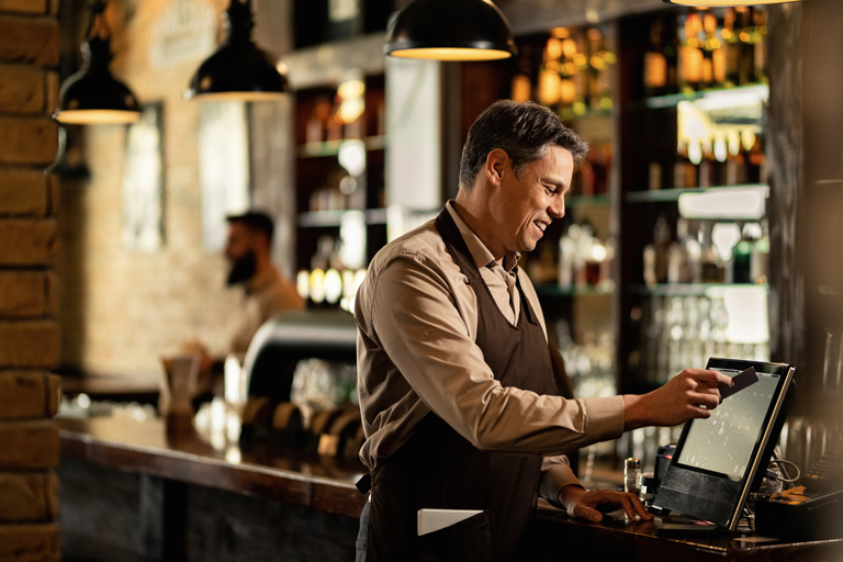 Waiter swiping a customer's credit card on a point of sale system