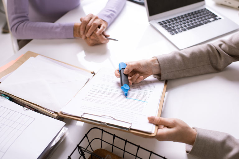 Woman highlighting a paragraph on a document that she's showing to a customer