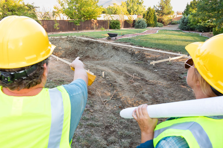 2 Contractors building a backyard pool